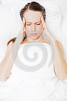 Woman with migraine lying in the bed