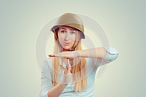 Woman in military capgesturing time out  with hand