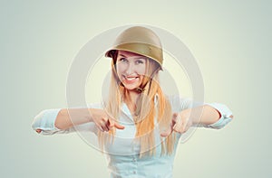 Woman in military helmet pointing fingers at you camera