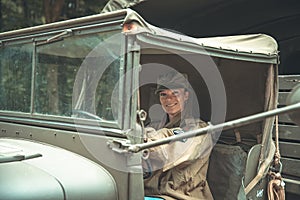 Woman in a military uniform in an army car