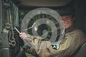 Woman in a military uniform in an army car