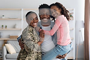 Woman in military uniform with her family at home