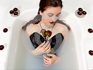 Woman milk water bath red roses candles