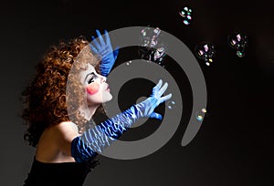 Woman mime with theatrical makeup and soap bubbles.