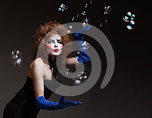 Woman mime with theatrical makeup and soap bubbles.