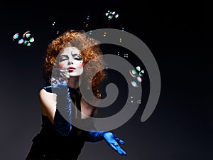 Woman mime with theatrical makeup and soap bubbles.