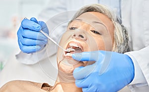 Woman, mirror and hands of dentist cleaning, check and dental wellness in clinic. Oral, orthodontics and mature patient