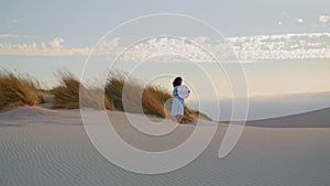 Woman mirror standing sand desert summer evening. Girl posing in front gray sky.