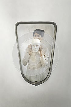 Woman in the mirror takes off her mask, concept of introspection and identity crisis