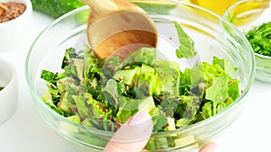 Woman mix salad of fresh green vegetables and herbs. Raw food concept. Vegan menu. Cooking healthy diet or vegetarian