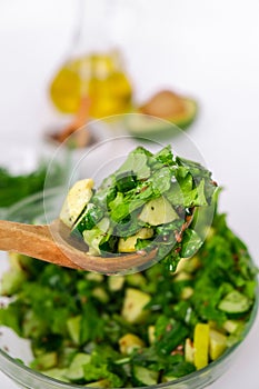 Woman mix salad of fresh green vegetables and herbs. Raw food concept. Vegan menu. Cooking healthy diet or vegetarian