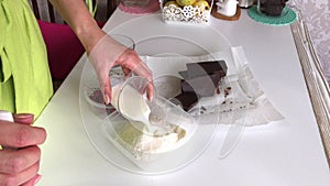 A woman mixes coconut, sugar and milk. Cooking Levington Pie