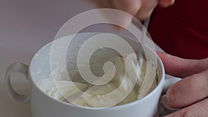 A woman mixes a cream cheese to lubricate the wafer cake layers.