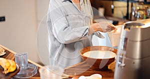 Woman mixing daugh for baking waffles at home