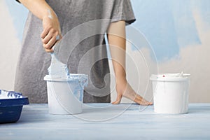 Woman mixing pigment and paint for wall painting