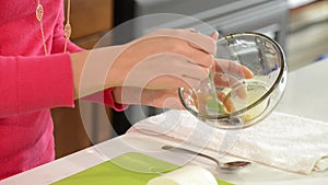 Woman mixing sauce in a glass bowl.