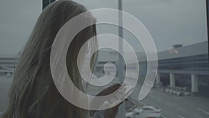 Woman with mobile phone at the airport