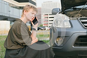 Woman with mobile phone calls technical assistance on the road