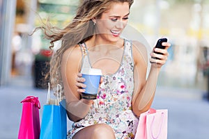 Woman with mobile phone and shopping bags