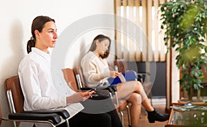 Woman with mobile phone waiting for job interview