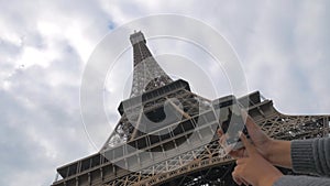 Woman with mobile taking picture of Eiffel Tower