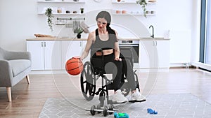 Woman with mobility impairment dribbling ball in studio apartment on weekend.