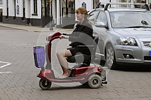 Woman on mobility scooter crossing a street