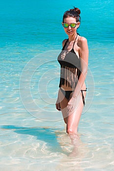 Woman model bathing in blue water on the beach of Phi Phi Island, Thailand.