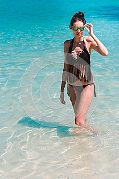 Woman model bathing in blue water on the beach of Phi Phi Island, Thailand.