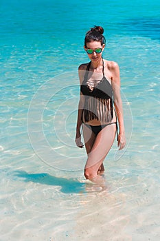 Woman model bathing in blue water on the beach of Phi Phi Island, Thailand.