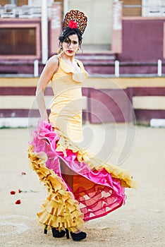 Woman, model of fashion, wearing a dress in a bullring