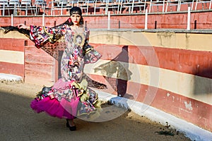 Woman, model of fashion, wearing a dress in a bullring