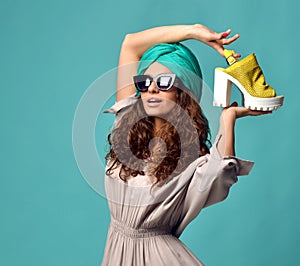 Woman in modern cat eyes sunglasses with white yellow shoe