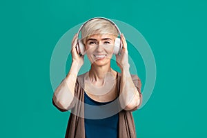Woman in modern headphones listening to music.