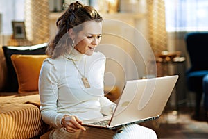 Woman in modern living room in sunny winter day using website