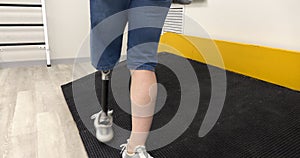 A woman with a modern robotic prosthetic leg is working out in the gym. Physiotherapy rehabilitation that allows a