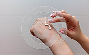 Woman moisturizing her hand with cosmetic cream.