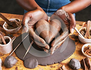 Woman molding heart from clay