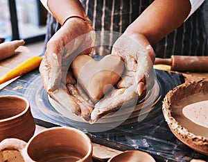 Woman molding a heart out of clay