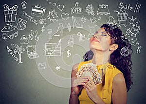 Woman with money dreaming how to spend it all