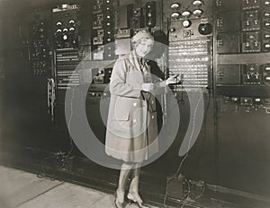 Woman monitoring sound in 1930s recording studio