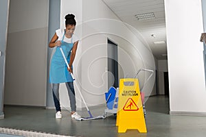 Woman Mopping Corridor