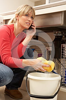 Woman Mopping Up Leaking Sink photo