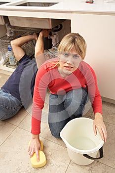 Woman Mopping Up Leaking Sink