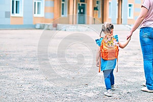 Mother accompanies to school and supports her daughter morally, holding hands photo