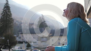 Woman In Morning On The Veranda Breathes Fresh Mountain Air And Exhales Steam