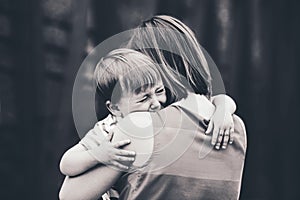 Woman mother comforting her crying little toddler boy son