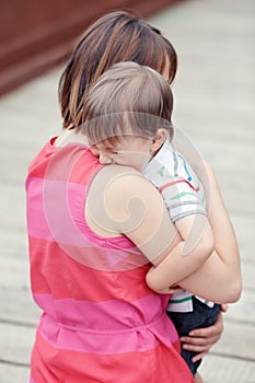 Woman mother comforting her crying little toddler boy son