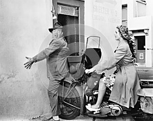 Woman on a motorbike running into a wall and hitting a man