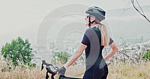 Woman, mountain bike and cliff view for exercise rest or training commitment, fitness or workout. Female person, helmet